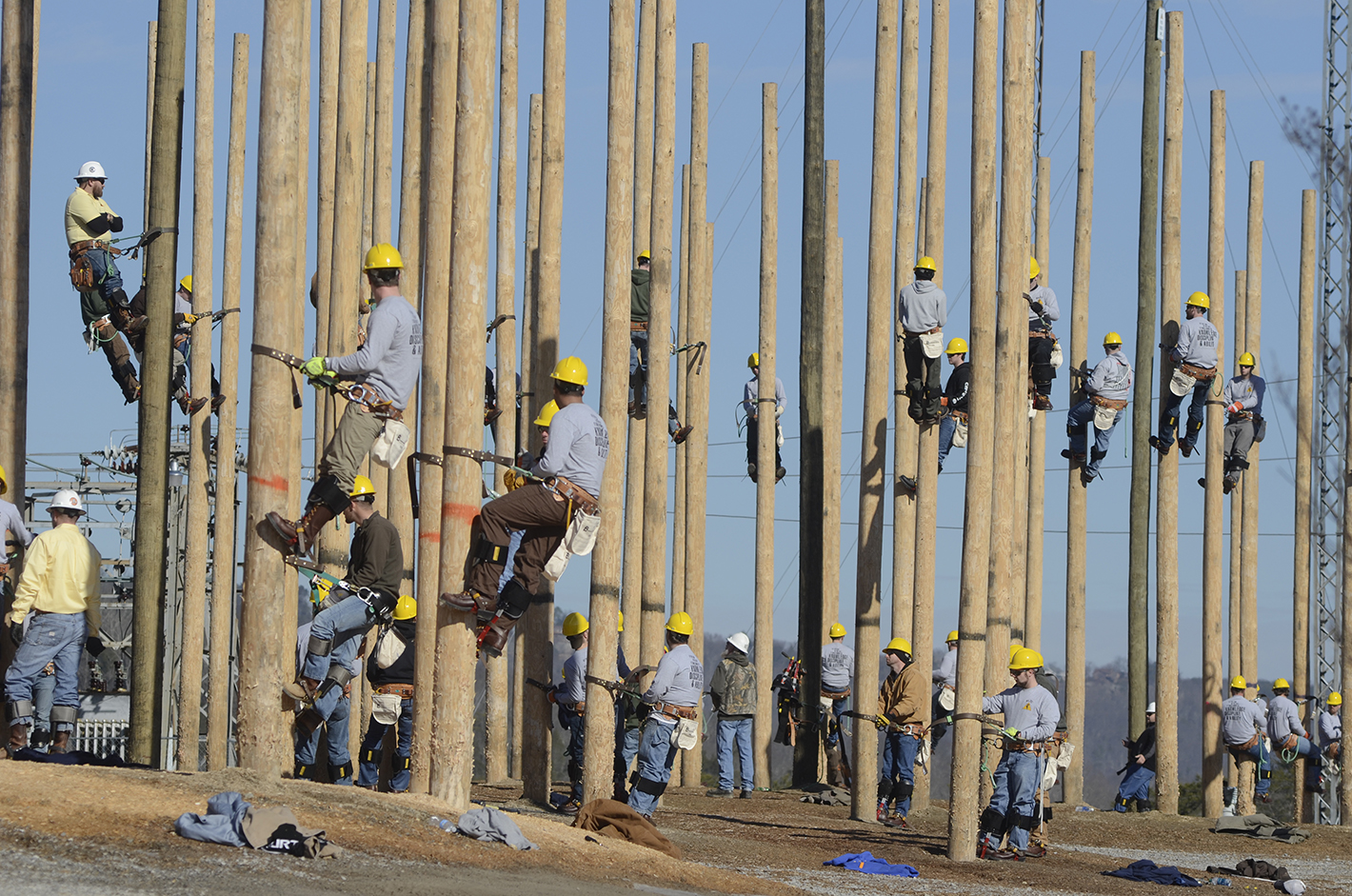 Linemen-in-training climb utility poles Thursday at the Southeast Lineman Training Center south of Trenton. A crew from Super Chief, a Chattanooga video production company, records the actions of a class for "Woodwalkers," a reality TV show.