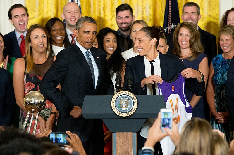 
              President Barack Obama puffs out his chest as former Phoenix Mercury guard Diana Taurasi presents him with an XL jersey in the East Room of the White House in Washington, Wednesday, Aug. 26, 2015, during a ceremony where the president honored the 2014 WNBA basketball Champions Phoenix Mercury. (AP Photo/Andrew Harnik)
            