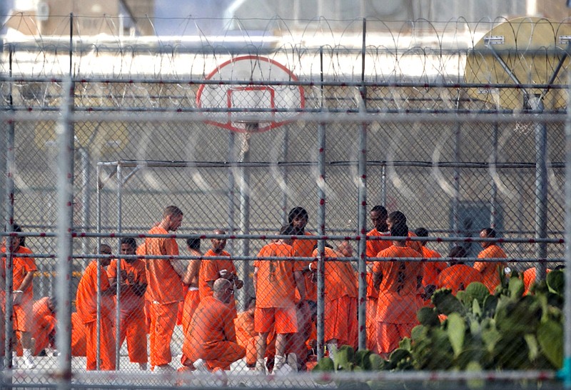 
              FILE - In this July 4, 2015 file photo, prison inmates stand in the yard at Arizona State Prison-Kingman in Golden Valley, Ariz. Arizona is severing ties with the private prison operator over what the state says was a string of security and training lapses that led to violent riots in July. Arizona Gov. Doug Ducey announced the action against Management and Training Corp. after the state released a scathing report about numerous issues at the prison. Ducey said what happened at the prison was “frightening, disturbing and completely unacceptable.”(Patrick Breen/The Arizona Republic via AP, File) MARICOPA COUNTY OUT - NO MAGS- NO SALES - MANDATORY CREDIT
            