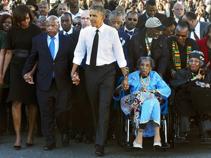 In this March 7, 2015, file photo, President Barack Obama, center, holds hands with Rep. John Lewis, D-Ga., left, and Amelia Boynton Robinson, right, who were both beaten during "Bloody Sunday," as they walk across the Edmund Pettus Bridge in Selma, Ala., for the 50th anniversary of "Bloody Sunday."