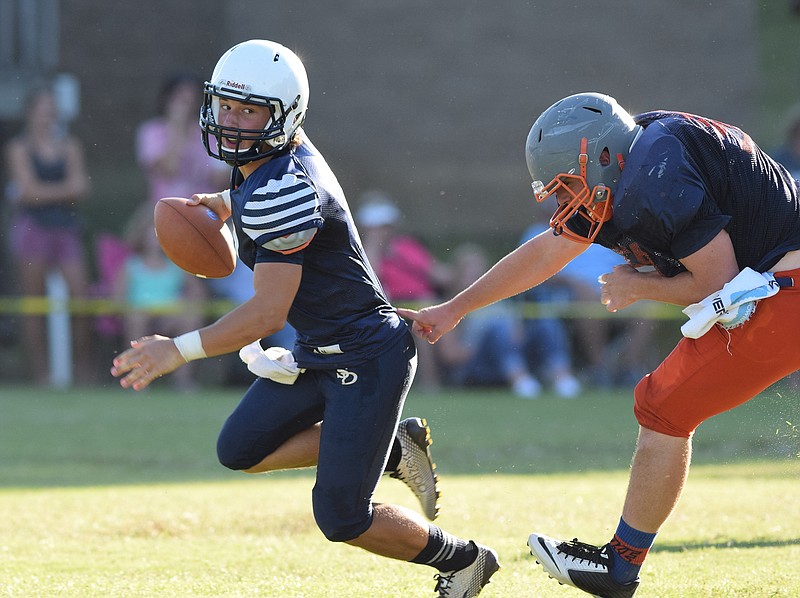 Soddy-Daisy quarterback Justin Cooke (2) escapes a East Ridge defender.  Five area high schools scrimmaged at Bradley Central High School Saturday, August 1, 2015.