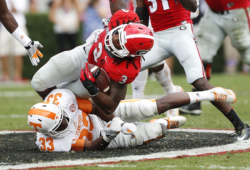 Georgia running back Todd Gurley (3) is brought down Tennessee defensive back LaDarrell McNeil (33) in the second half of an NCAA college football game  Saturday, Sept. 27, 2014, in Athens, Ga. Georgia won 35-32. (AP Photo/John Bazemore)  