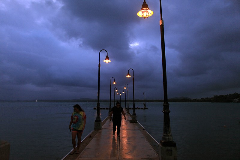 
              A couple walks on a pier under cloudy skies as Tropical Storm Erika approaches the island in Naguabo, Puerto Rico, Thursday, Aug. 27, 2015. Erika was expected to move near Puerto Rico and the Virgin Islands on Thursday and be near or just north of the Dominican Republic on Friday as it heads toward Florida early next week, possibly as a hurricane. (AP Photo/Ricardo Arduengo)
            