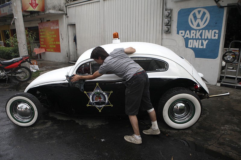 
              In this Friday, Aug. 7, 2015 photo, Dany Beltran polishes his 1956 Volkswagen beetle, named the Beltran Volk's Sheriff, outside of his family's Volkswagen repair and service shop in Mexico City. Beltran's uncle gave him the car when he was 13 years old so he could learned how to remodel and repair beetles. (AP Photo/Sofia Jaramillo)
            