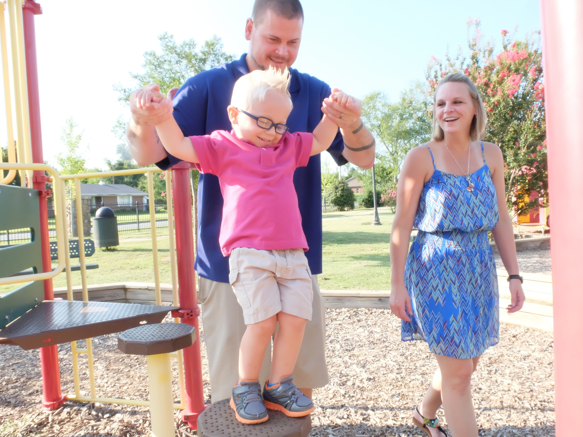 With mother Amy walking along, Chance Hall, 2, receives assistance from his dad, Nolan, while playing at the Ringgold City Park. Chance suffers from Klippel-Feil syndrome, a disease that affects the spine and causes his head to sit at an angle.