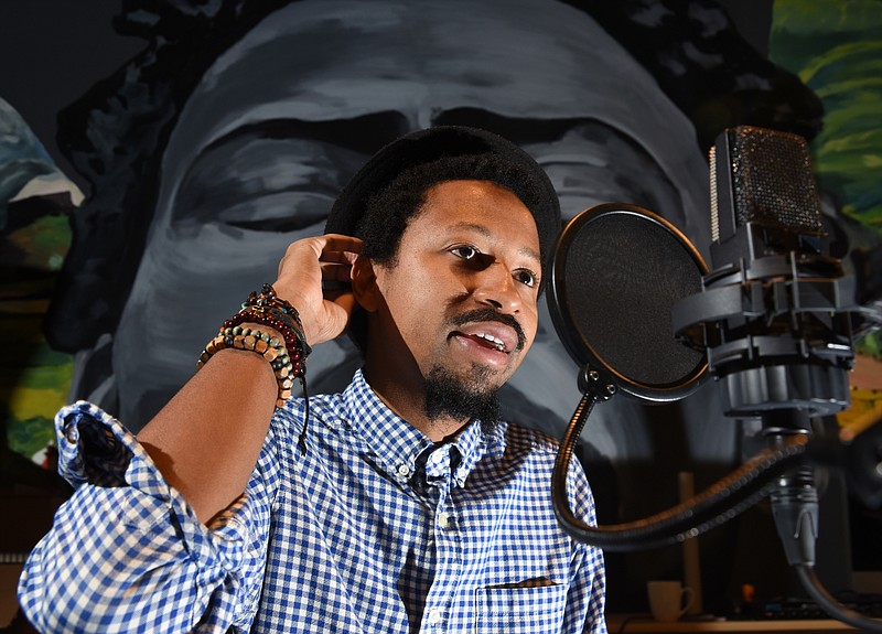 Russell Magee, 30, sits at the microphone in studio at the Fancy Rhino offices on Market Street. Magee goes by the name, Genisis the Greykid, when he performs his poetry. 