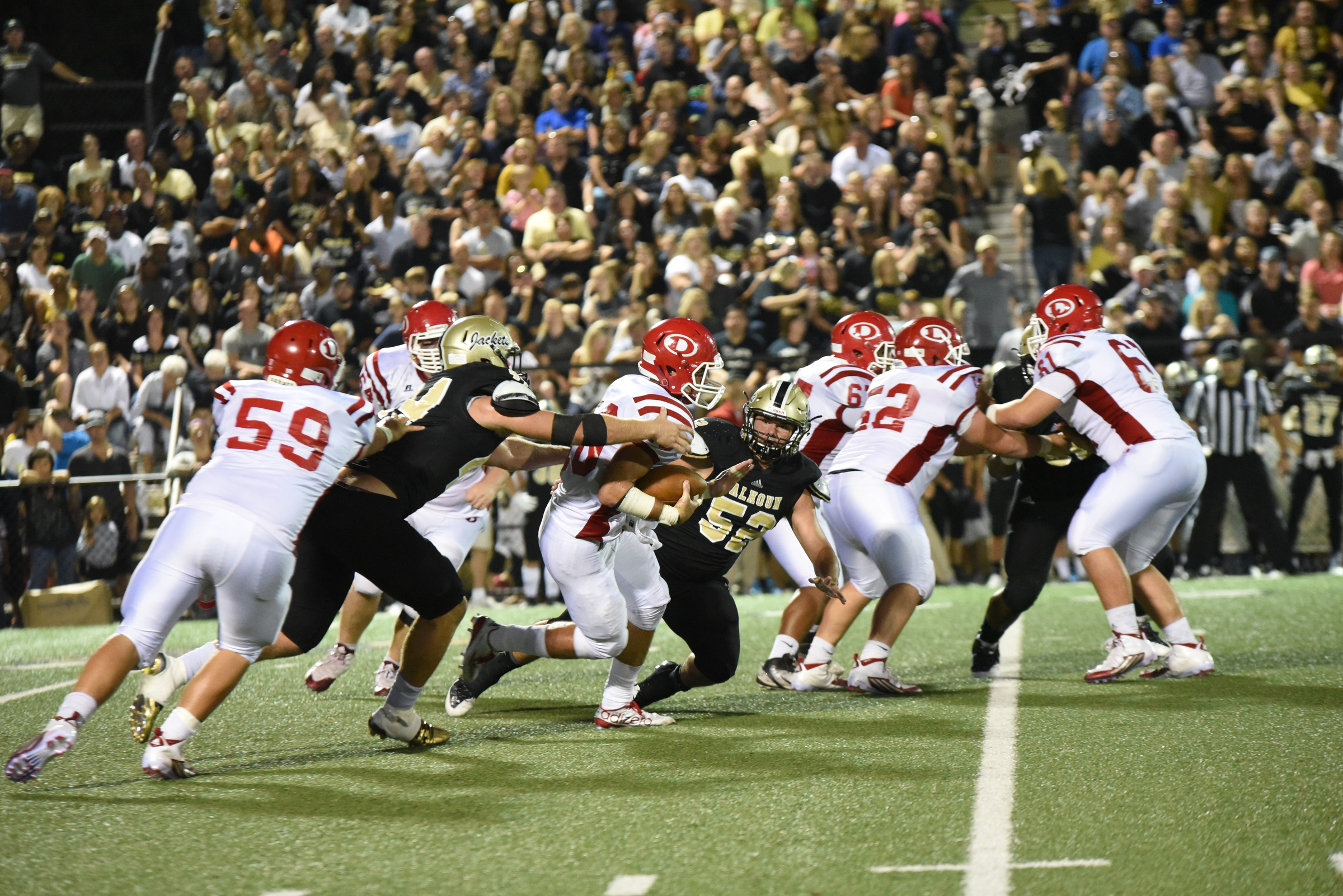 Dalton's Jase Chastain (10) tries to escape the reach of Calhoun's Landon Rice, left, and Blaine Anderson (52) in second quarter action at Calhoun.