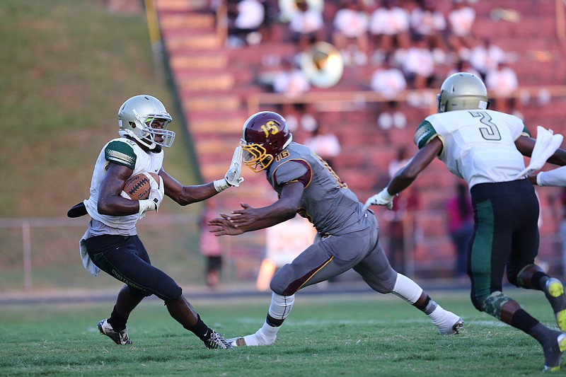 Notre Dame running back Ricky Ballard (5) dodges a tackle from Tyner quarterback Shaylan Bailey (16) during the Notre Dame vs. Tyner prep football game at Tyner High School on Friday, Aug. 28, 2015 in Chattanooga, Tenn. (Staff photo by Maura Friedman)
