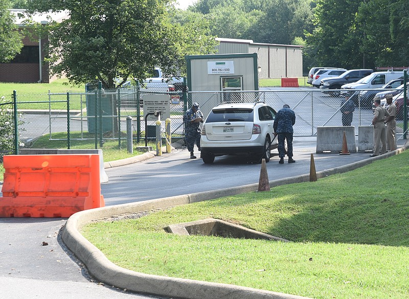 Service men inspect a vehicle at the entrance to the U.S. Naval and Marine Reserve Center Wednesday morning on Amnicola Highway.