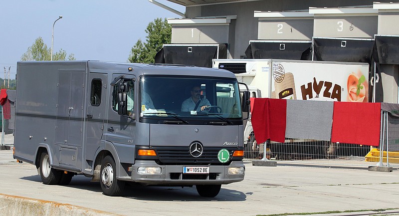 
              Blankets cover the view on a truck that is investigated at a veterinary border station as a hearse passes by at the Austrian/Hungarian border in Nickelsdorf, Austria, Friday, Aug 28, 2015. The truck was found parked on a main Austrian highway on Thursday with 71 migrants suffocated to death. (AP Photo/Ronald Zak)
            