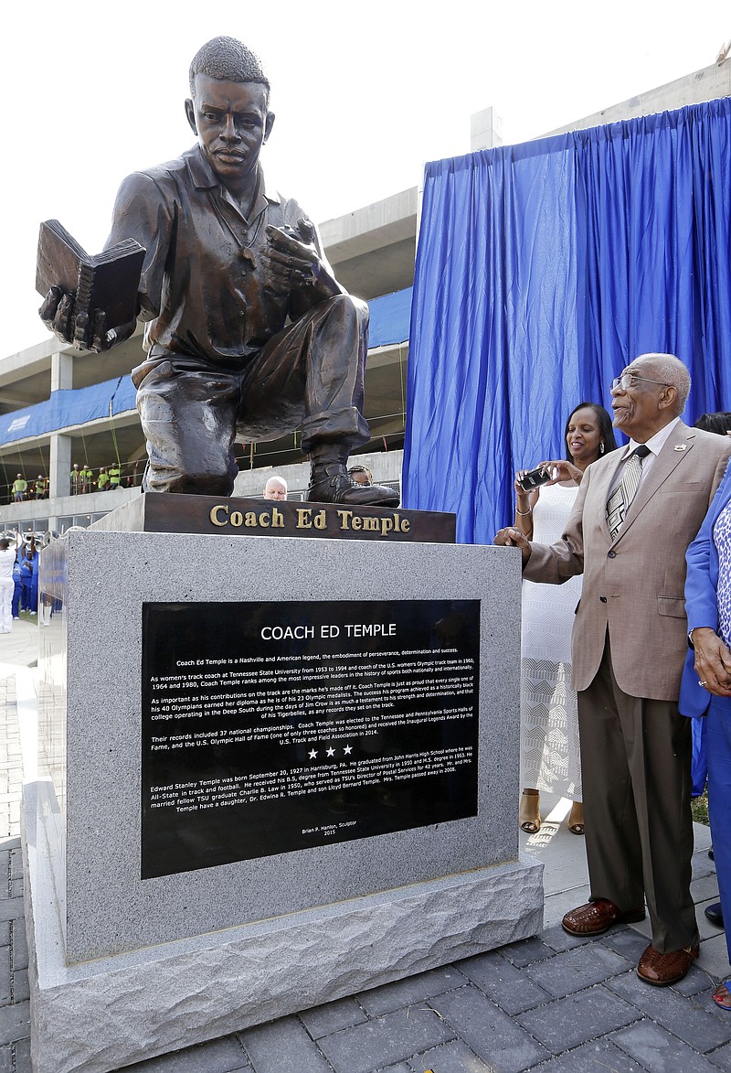 
              Former Tennessee State and Olympic women's track coach Ed Temple, right, looks at his statue as it is dedicated Friday, Aug. 28, 2015, in Nashville, Tenn. Temple coached at Tennessee State from 1953 to 1994, and his athletes won 13 Olympic gold medals during those years. (AP Photo/Mark Humphrey)
            