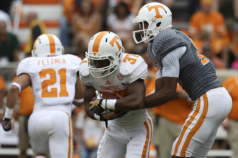 Staff Photo by Dan Henry / The Chattanooga Times Free Press- 4/25/15. The University of Tennessee's Jauan Jennings (15) hands off to Jayson Sparks (37) during the Dish Orange & White Game in Knoxville on Saturday, April 25, 2015. Final score was Orange 54, White 44.