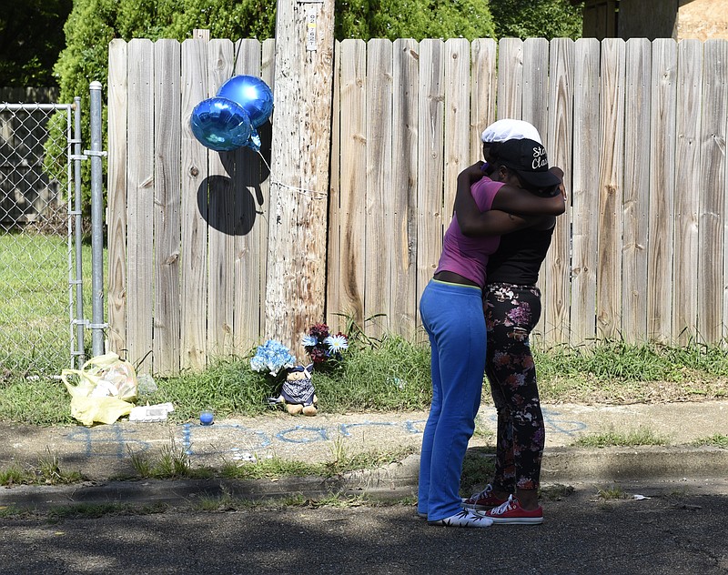 Jala Smith, left, and Asia Smith embrace at a roadside memorial on Wednesday, Aug. 26, 2015, in Chattanooga, Tenn., in the aftermath of a Tuesday night shooting in the 800 block of North Willow Street that killed their brother, 20-year-old Frederick Jordan Clark. 