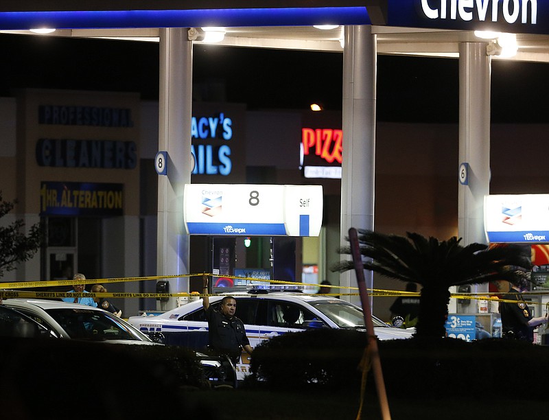 
              Officials investigate the scene at a gas station where a sheriff's deputy in uniform was fatally shot Friday, Aug. 28, 2015, in Houston. Harris County Sheriff's Office spokesman Ryan Sullivan said the deputy was pumping gas into his vehicle on Friday night when a man approached him from behind and fired multiple shots. (Karen Warren/Houston Chronicle via AP) MANDATORY CREDIT
            