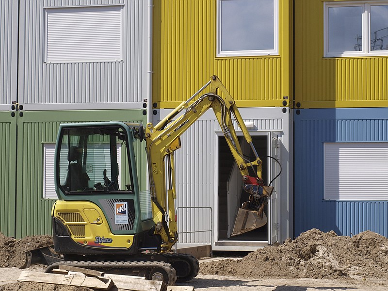 
              In this photo taken on Wednesday, Aug. 5, 2015, a digger stands in front of a container building under construction in Berlin. The building is meant to be a shelter for refugees seeking asylum in the German capital. The surge in migrants and refugees to Europe from Syria, Afghanistan, Iraq, Eritrea and elsewhere this year has sent countries scrambling to come up with housing - both temporary for those awaiting the outcome of asylum applications, and permanent for those allowed to stay. Many European countries face similar problems, but none greater than Germany. Europe’s richest economy attracted 43 percent of Europe’s 400,000 asylum applications in the first half of the year - more than double the number in the same period of 2014. (AP Photo/Olga Syrova)
            