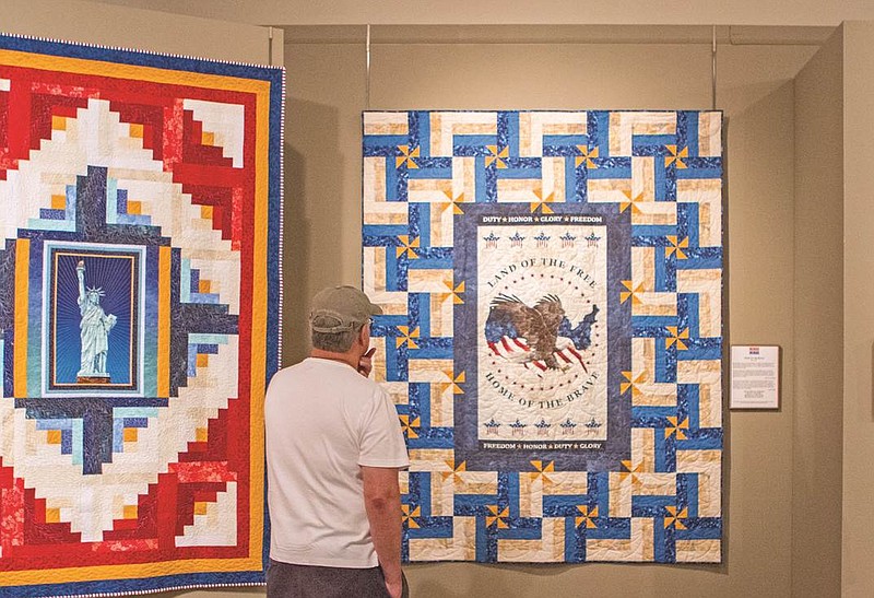 
              Carlos Mendez of Bowling Green, Ky.,  looks at a quilt titled “Home of the Brave” Friday, Aug. 28, 2015 at the National Quilt Museum in downtown Paducah. The quilt is one of 34 patriotically themed pieces on display as part of an exhibit brought to the museum by the Quilts of Valor Foundation.   (Kat Russell/The Paducah Sun via AP) MANDATORY CREDIT
            