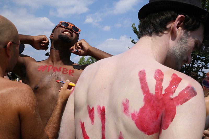 
              Participants in the Philly Naked Bike Ride paint each other before riding in Philadelphia on Saturday, Aug. 29, 2015. Thousands in various stages of undress have pedaled their way around the city to promote fuel conservation and positive body image. (Serge Levin/Metro via AP)
            