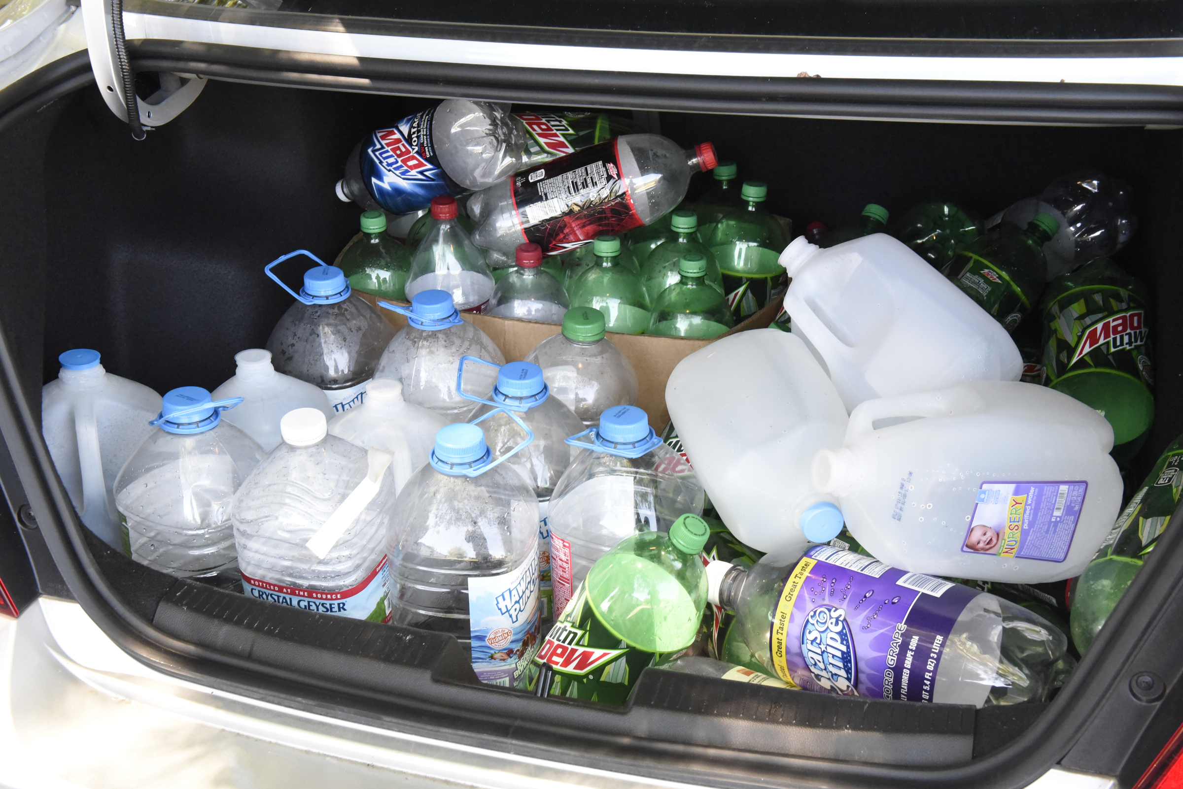Empty water bottles are seen in the trunk of a car at the Pear Pines Mobile Home Park on Tuesday, Aug. 25, 2015, in LaFayette, Ga. Few residents remain after the landlord's financial problems caused water to be turned off at the property several weeks ago.