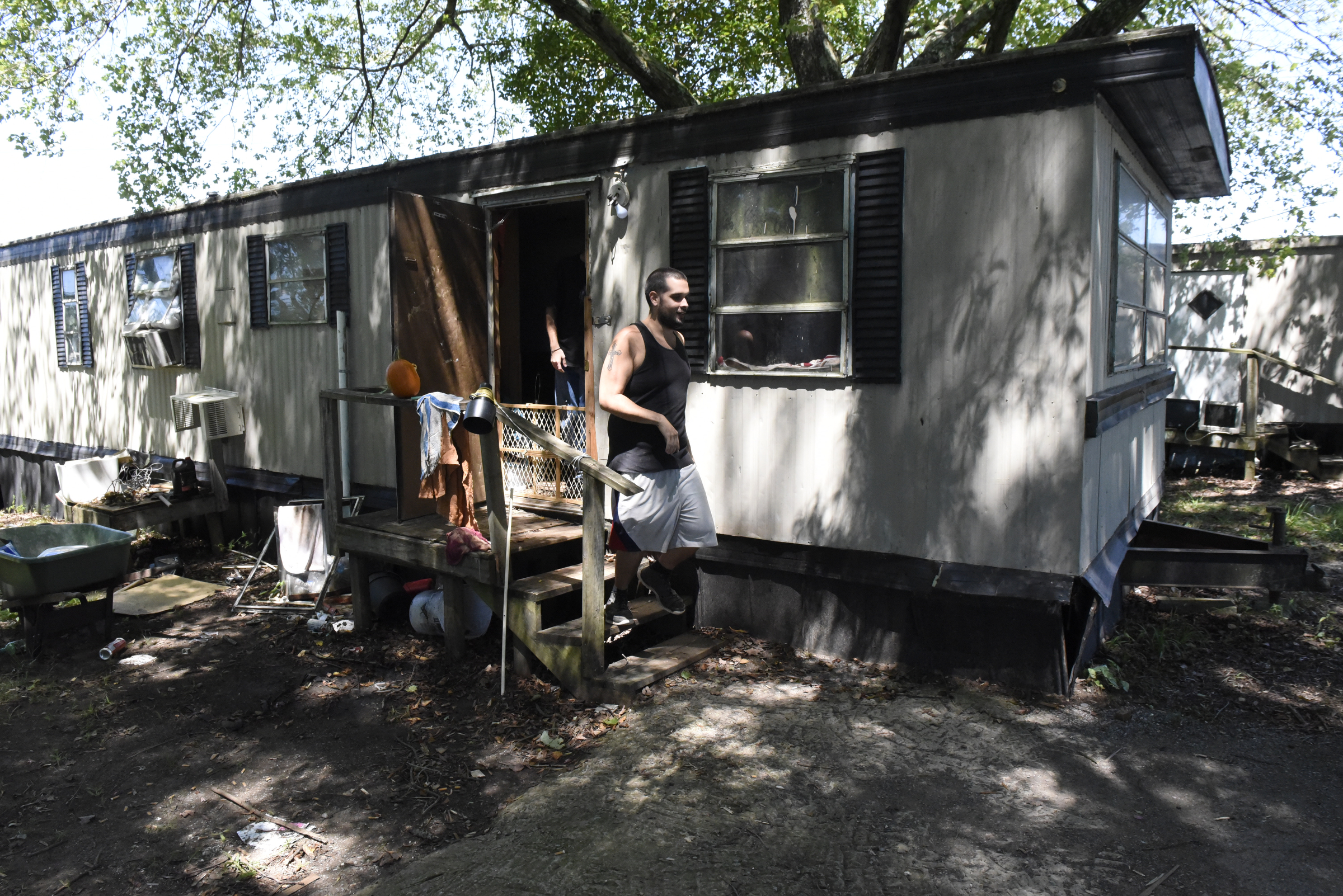 Kenny Patton walks down the steps at his residence at the Pear Pines Mobile Home Park on Tuesday, Aug. 25, 2015, in LaFayette, Ga. Few residents remain after the landlord's financial problems caused water to be turned off at the property several weeks ago.