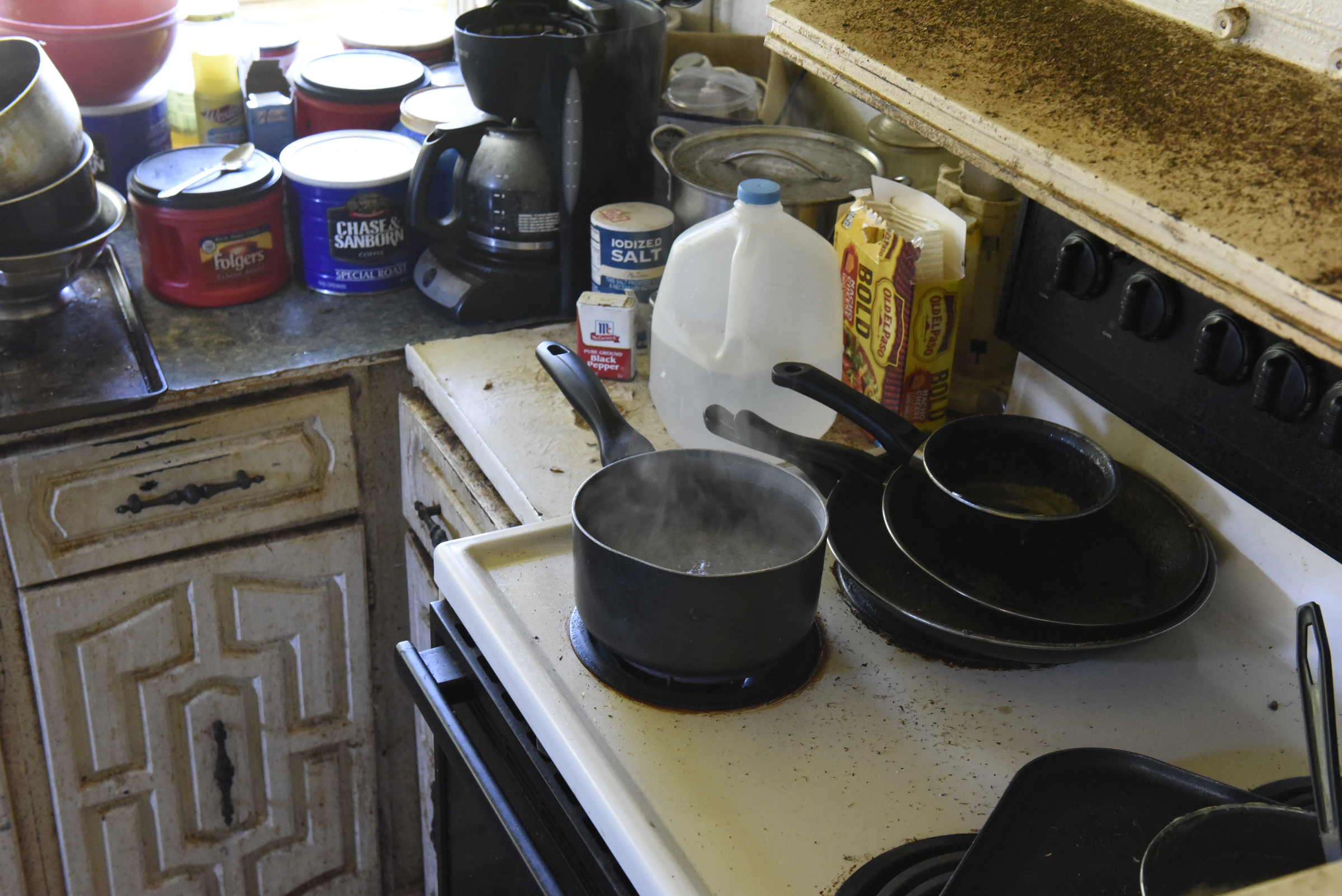 Nikki Cortez boils water on the stove in her residence at the Pear Pines Mobile Home Park on Tuesday, Aug. 25, 2015, in LaFayette, Ga. Few residents remain after the landlord's financial problems caused water to be turned off at the property several weeks ago.