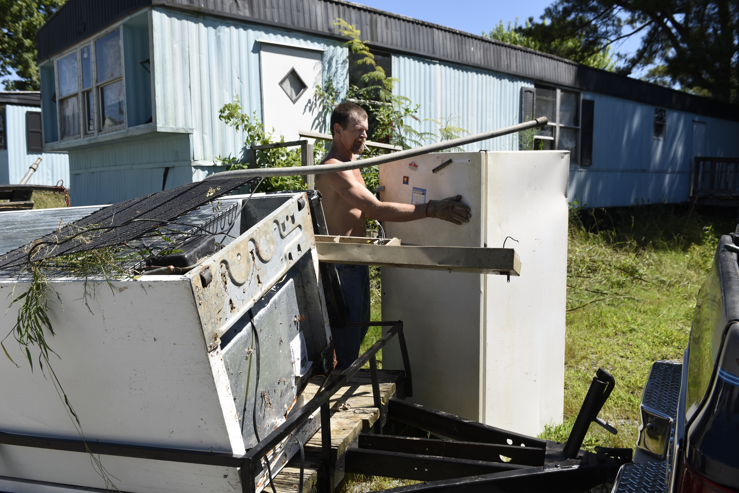 Resident Andy Anderson collects appliances and other scrap metal he is salvaging from abandoned mobile homes at the Pear Pines Mobile Home Park on Tuesday, Aug. 25, 2015, in LaFayette, Ga.