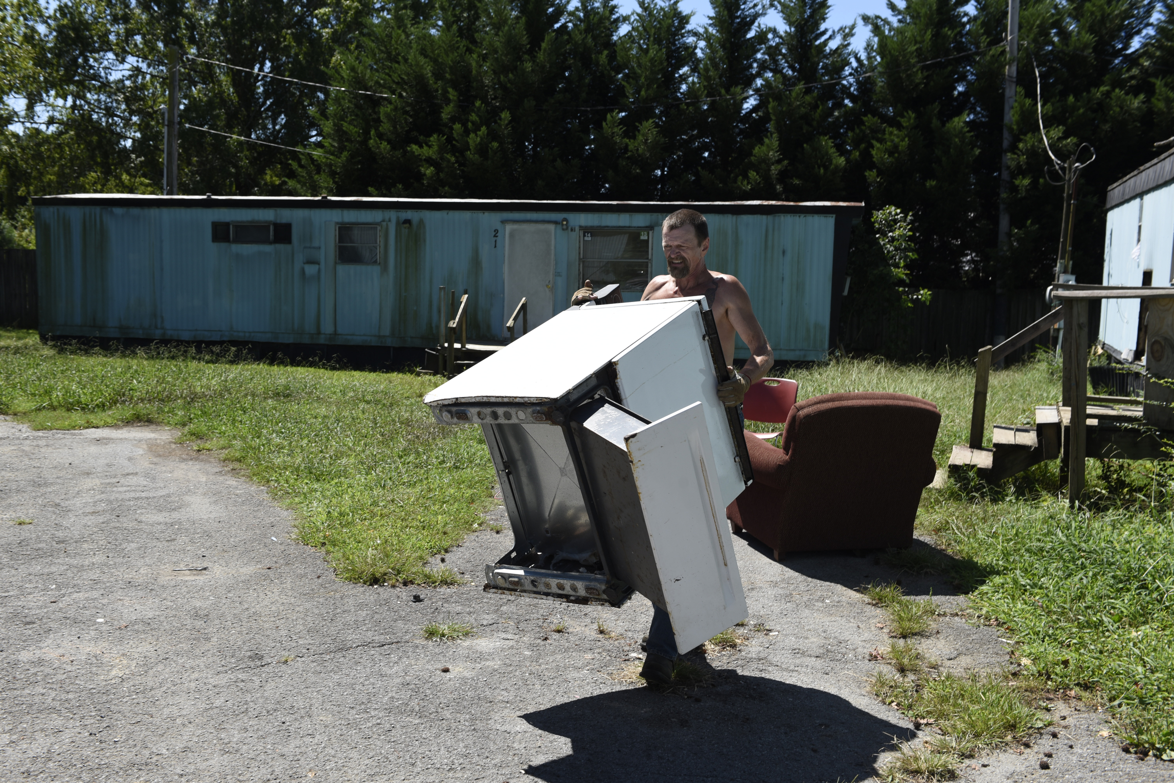 Resident Andy Anderson collects appliances and other scrap metal he is salvaging from abandoned mobile homes at the Pear Pines Mobile Home Park on Tuesday, Aug. 25, 2015, in LaFayette, Ga.