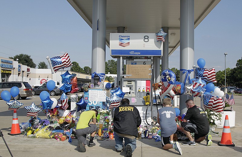 
              Mourners gather at a gas station in Houston on Saturday, Aug. 29, 2015 to pay their respects at a makeshift memorial for Harris County Sheriff's Deputy Darren Goforth who was shot and killed while filling his patrol car. On Saturday, prosecutors charged Shannon J. Miles with capital murder in the Friday shooting. (James Nielsen/Houston Chronicle via AP) MANDATORY CREDIT: JAMES NIELSEN/HOUSTON CHRONICLE
            