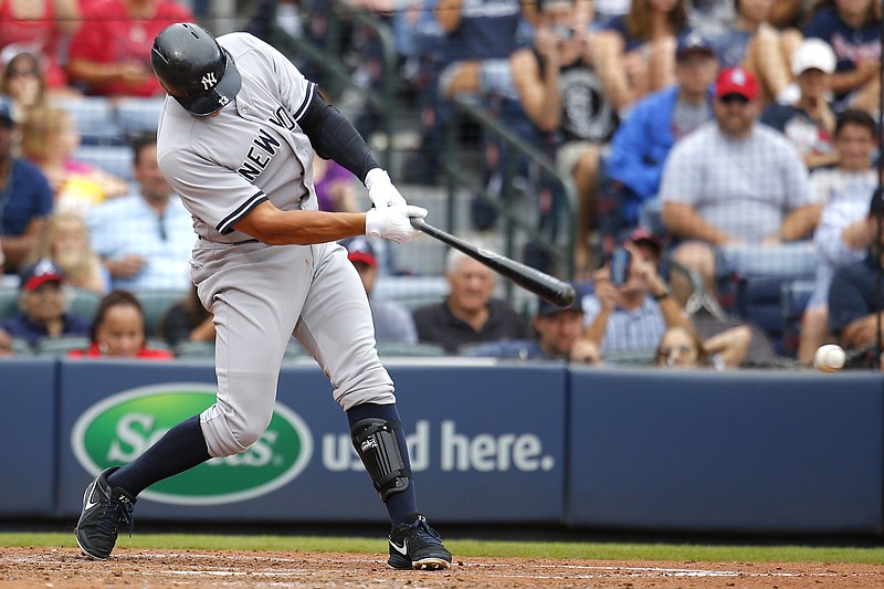 New York Yankees designated hitter Alex Rodriguez singles to bring in two runs in the seventh inning of a baseball game against the Atlanta Braves, Sunday, Aug. 30, 2015, in Atlanta. 