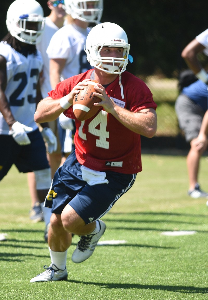 Quarterback Jacob Huesman rolls out to pass during the first day of football practice for the University of Tennessee at Chattanooga on Sunday, Aug. 3, 2015, in Chattanooga, Tenn.