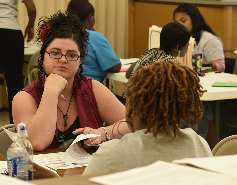 Applicant Stephani Combs, left, talks with CHA employee Shelah (CQ) Griggs as she and others apply for housing vouchers at the Chattanooga Housing Authority offices on Monday, Aug. 31, 2015, in Chattanooga, Tenn. The vouchers will be awarded on Thursday. 