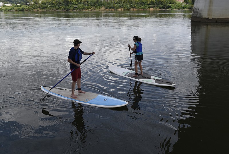 David and Anna Scharff bring their paddleboard rentals back to the pier underneath the Market Street Bridge on Monday, Aug. 31, 2015, in Chattanooga, Tenn. Employees of SUP Paddleboards carry the boards to and from the river.