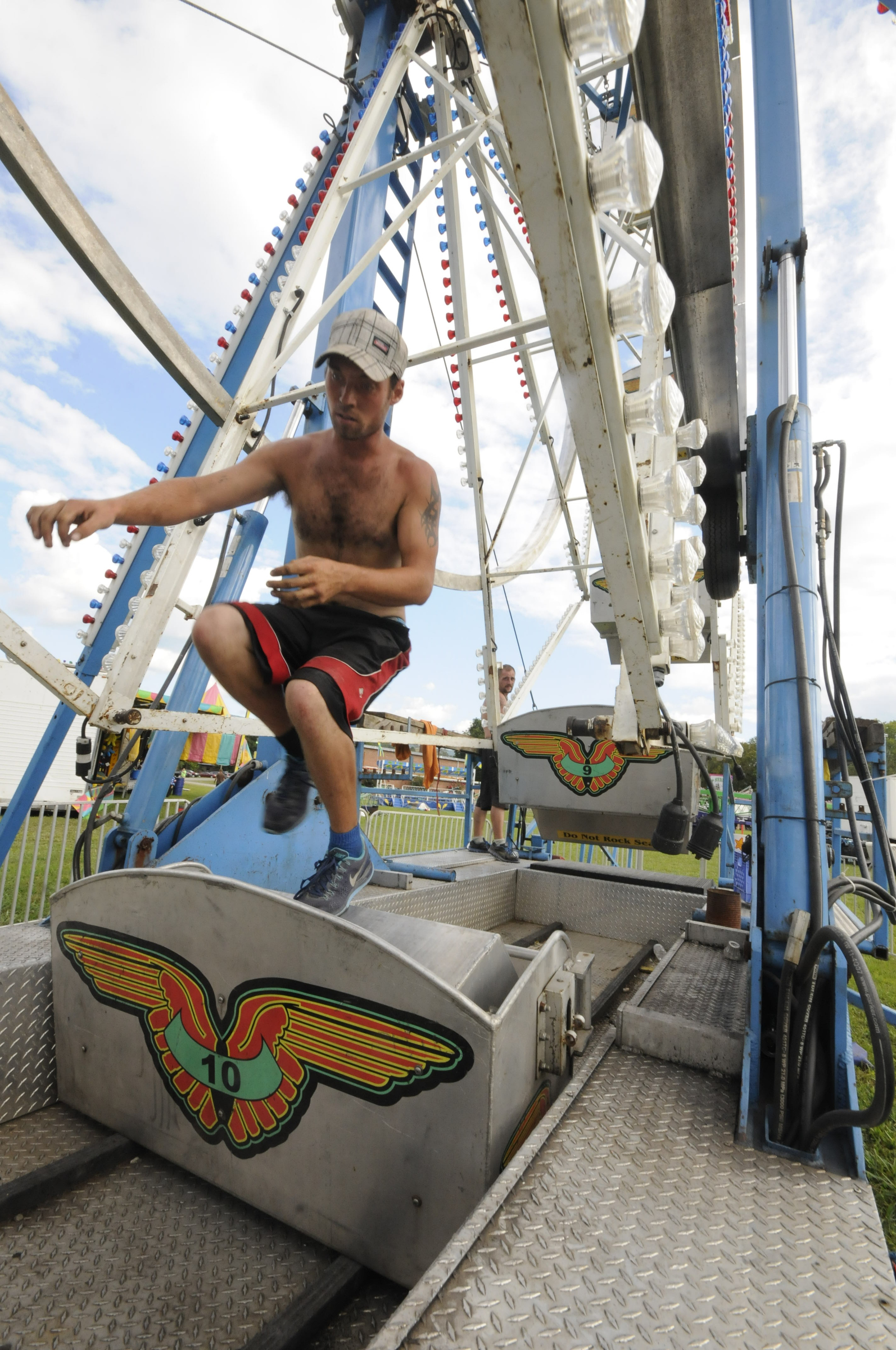 Aaron Saurbek steps over one of the ferris wheel seats as carnival construction begins Monday afternoon at the 88th Annual Sequatchie County Fair in Dunlap. The fair opens Wednesday and runs through Monday, Sept. 7.