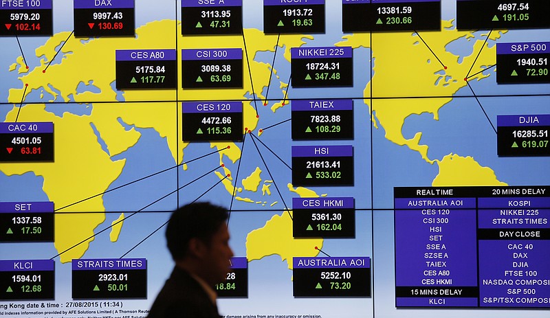 
              FILE - In this Aug. 27, 2015 file photo, a man walks past a bank's electronic board showing the share index around the world at Hong Kong Stock Exchange. Investors have yanked $40 billion from emerging-market stocks this year, a record pace of withdrawals, as a slowdown in China has hammered companies that supply raw materials. (AP Photo/Vincent Yu, File)
            