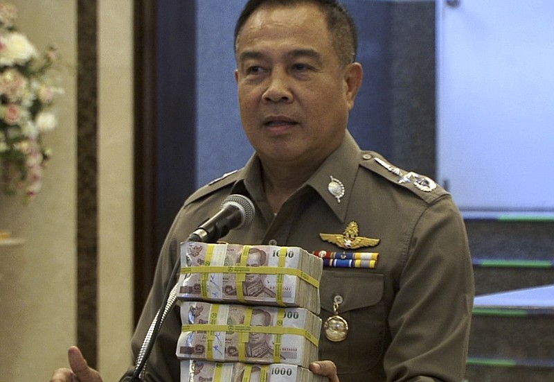 
              In this image taken from video, National police chief Somyot Poompanmoung holds a cash reward at a press conference in Bangkok, Thailand, Monday, Aug. 31, 2015. Thai police have awarded themselves a 3 million baht ($84,000) reward offered to the public for tips leading to the arrest of suspects in Bangkok’s deadly bombing after a man was arrested over the weekend in an apartment where police found bomb-making equipment. (AP Photo/AP Video)
            