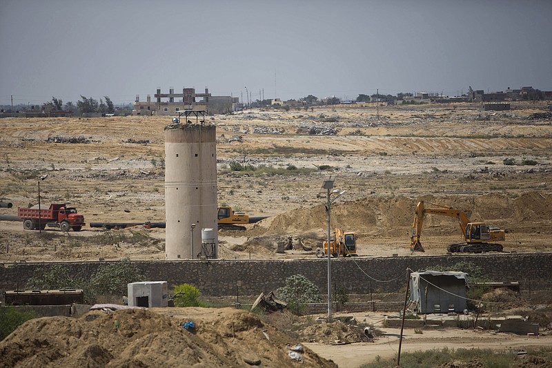 
              In this Sunday, Aug. 30, 2015 photo, bulldozers and diggers work on the Egyptian side of the border with the Gaza Strip. Egyptian military bulldozers have been digging through the sand along the border in recent days, pressing ahead with what appears to be a renewed campaign to pressure Gaza’s Hamas rulers and stamp out militant activity along the border.(AP Photo/Khalil Hamra)
            