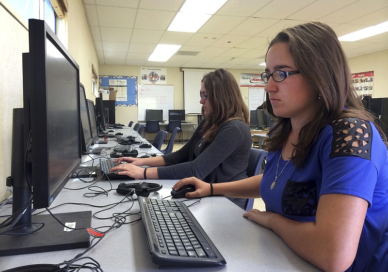 
              FILE - In this April 30, 2015 file photo, Leticia Fonseca, 16, left, and her twin sister, Sylvia Fonseca, right, work in the computer lab at Cuyama Valley High School after taking the new Common Core-aligned standardized tests, in New Cuyama, Calif.   Test results for this year’s Common Core-aligned exams are starting to be released, and while several states report higher-than-expected scores, vast numbers of students didn’t test proficient in math or reading.(AP Photo/Christine Armario, File)
            