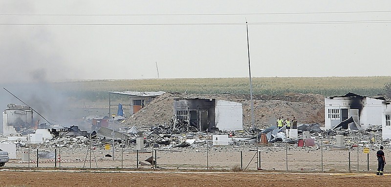 
              Police officers and firefighters stand by the destroyed fireworks factory Pirotecnia Zaragozana's building after a huge explosion  in Pinseque, Spain, Monday, Aug. 31, 2015. The blast at a fireworks factory in northeastern Spain killed a number of people and seriously injured tothers, police and firefighters didn't know the cause of the blast.  (AP Photo/Aranzazu Navarro)
            