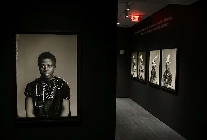 
              In this Thursday, Aug. 27, 2015, photo, an 1891 portrait of Johanna Jonkers, sitting for a London Stereoscopic Company photographer, hangs with other portraits made in studios across Britain in the 19th and early 20th century, being installed for the show "Black Chronicles II" at the Ethelbert Cooper Gallery of African & African American Art in Cambridge, Mass. The show runs from Wednesday, Sept. 2, through Friday Dec. 11, 2015. (AP Photo/Stephan Savoia)
            