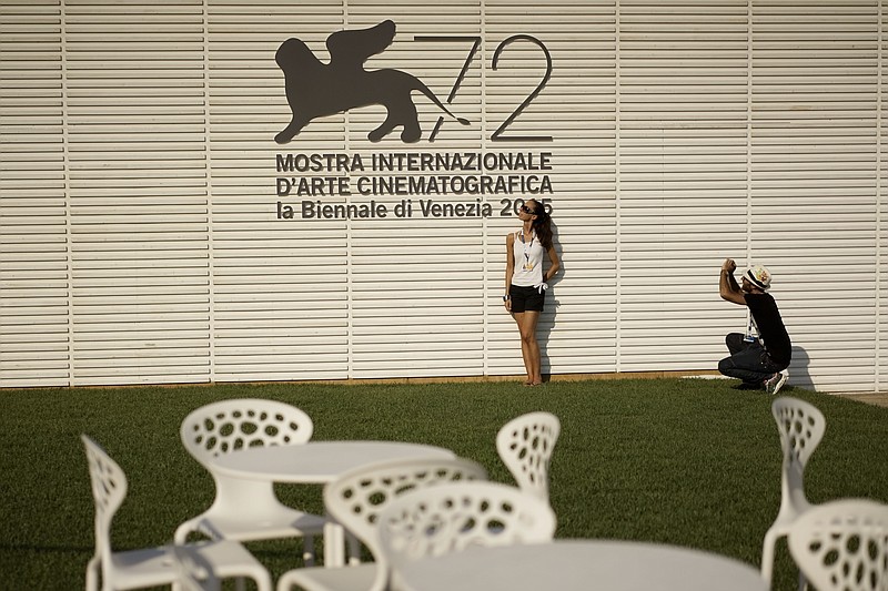 
              People take souvenir photos in front of the logo of the 72nd edition of the Venice Film Festival, at the Venice Lido, Monday, Aug. 31, 2015. The world's oldest movie festival will open on  Sept. 2 through Sept. 12. (AP Photo/Andrew Medichini)
            