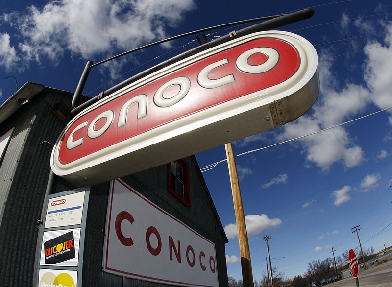 
              FILE - In this March 8, 2008 file photo, clouds hover over Conoco signs at a service station in Glenrock, Wyo. Energy company ConocoPhillips on Tuesday, Sept. 1, 2015 said it is cutting around 1,810 jobs, or 10 percent of its workforce, following a plunge that took oil prices to their lowest levels in years. (AP Photo/David Zalubowski, File)
            