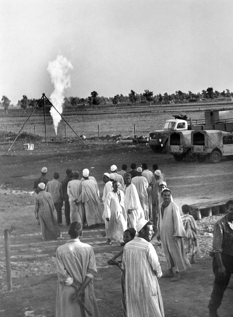 
              FILE - In this Nov. 25, 1966 file photo, farmers look at a towering flame at an outburst of natural gas, discovered by the Italian oil company ENI in the Nile Delta region of Kafr el-Sheikh, Egypt. Italian energy company Eni SpA said Sunday, Aug. 30, 2015, that it found the “largest-ever” gas field in the Mediterranean Sea off Egypt’s shores. Egypt’s new natural gas bonanza is causing an uproar in Israel, with energy stocks plummeting and recriminations over dithering and infighting that has delayed production from the country’s own gas fields. (AP Photo/Aly Mahmoud)
            