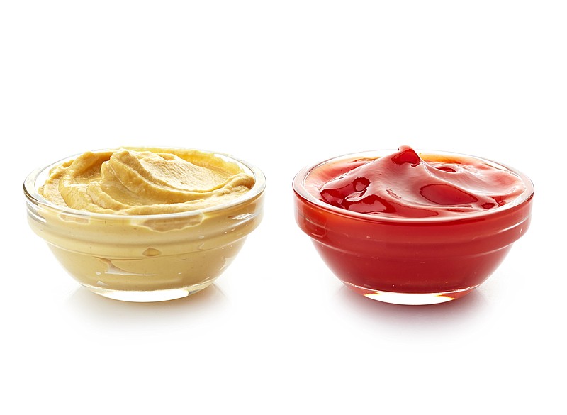 Bowls of mustard sauce and ketchup are displayed.