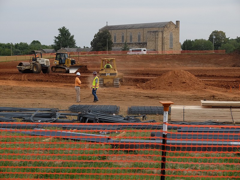 In the shadow of First Cumberland Presbyterian Church in Brainerd, building supplies lay nearby as grading work continues late Wednesday for the new Wal-Mart store at the corner of Moore and Shallowford Roads.