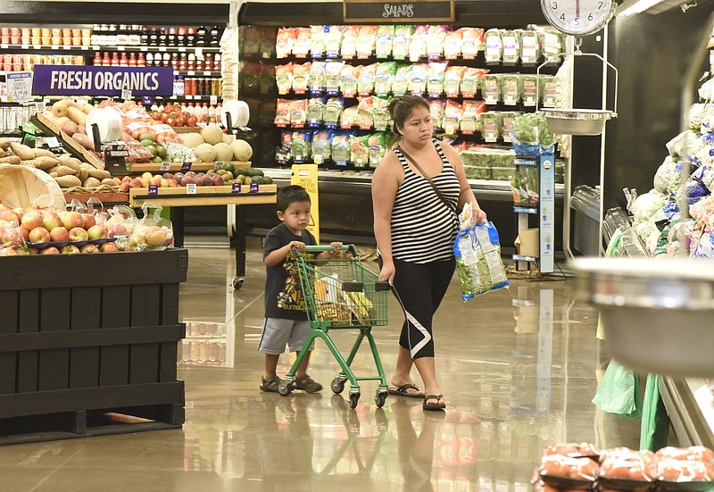 Aaron Andres, age 3, pushes a small grocery cart as he shops with his aunt Veronica Andres on the first day of business for the new Food City grocery store Wednesday, Sept. 2, 2015, in Red Bank, Tenn. The store, formerly a Bi-Lo at the intersection of Morrison Springs Road and Dayton Boulevard, was reopened after a three-day turnaround. 