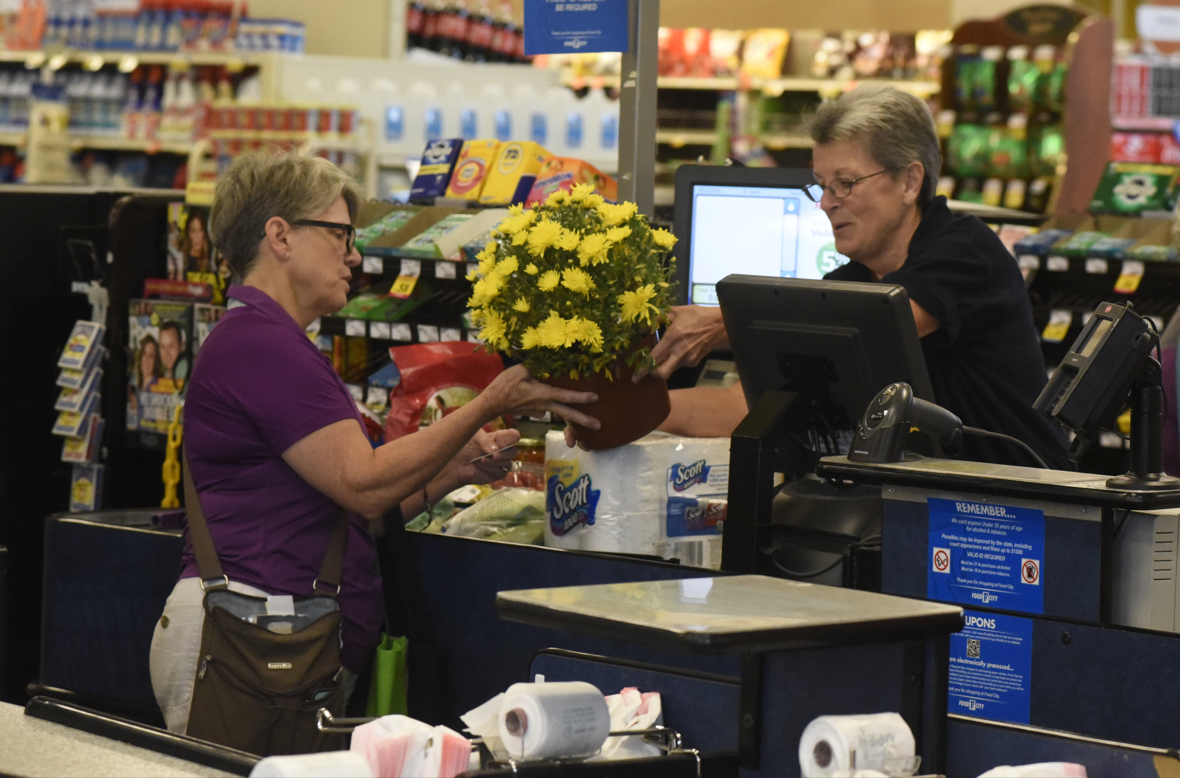 Marsha Thibadoux, left, from Hixson, buys flowers and other items as she is checked out by cashier Colleen Frank on the first day of business for the new Food City grocery store Wednesday, Sept. 2, 2015, in Red Bank, Tenn. The store, formerly a Bi-Lo at the intersection of Morrison Springs Road and Dayton Boulevard, was reopened after a three-day turnaround.