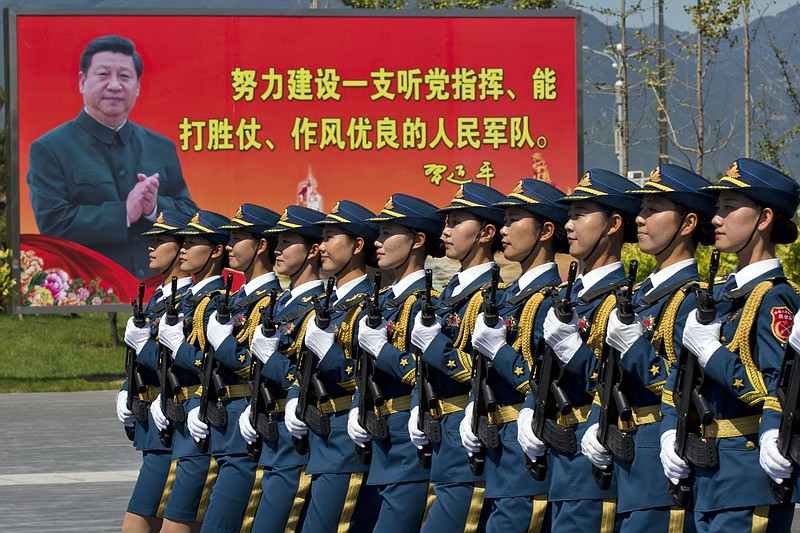 
              FILE - In this Aug. 22, 2015 file photo, Chinese female troops practice marching near a billboard showing Chinese President Xi Jinping and the slogan "Strive to build a People's Liberation Army that obeys the Party, Wins the war and has outstanding work style“ at a camp on the outskirts of Beijing. China is leaning on the animal kingdom - including a squad of nest-wrecking monkeys - to ensure its military parade commemorating the end of World War II goes smoothly. To minimize the chances of birds striking engines during the many airplane flyovers connected to the Beijing parade, state media reports say, the military has used falcons to chase away birds and a team of trained macaques to flush nests out of trees around the pilots’ training grounds. (AP Photo/Ng Han Guan, File)
            