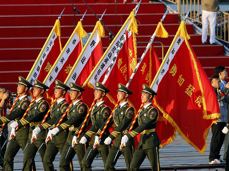 
              Paramilitary policemen carrying flags prepare in front of the Tiananmen Gate ahead of a parade commemorating the 70th anniversary of Japan's surrender during World War II held in front of Tiananmen Gate in Beijing, Thursday, Sept. 3, 2015. (AP Photo/Ng Han Guan)
            