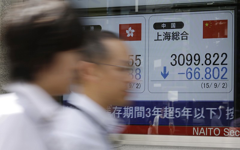 
              People walk past an electronic stock board of a securities firm showing Shanghai Index in Tokyo Wednesday, Sept. 2, 2015. Asian stocks extended a global market sell-off Wednesday as poor manufacturing data from the world's two biggest economies dampened investor sentiment. (AP Photo/Eugene Hoshiko)
            