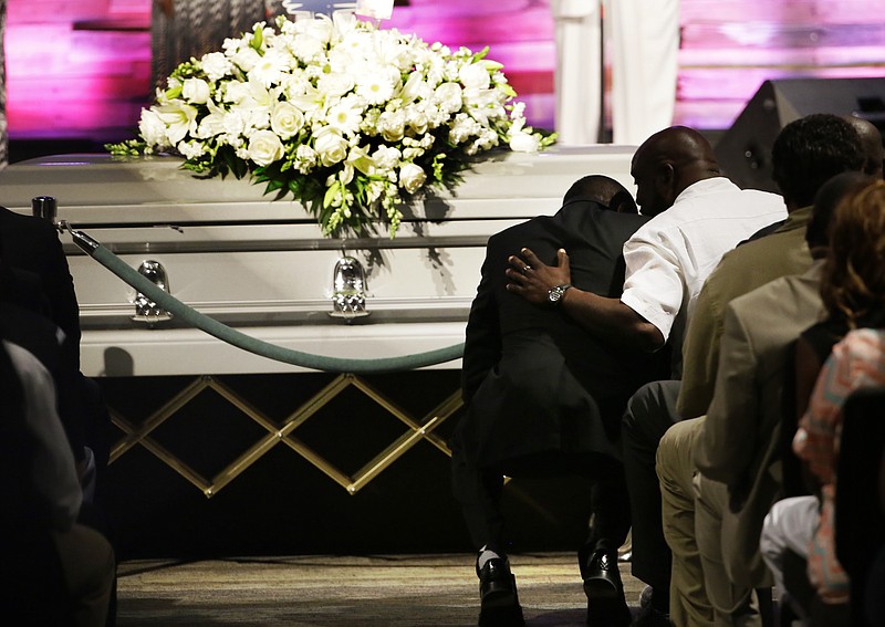 Pastor Ronnie Goines, left, leans in to listen to Adrian Taylor, father of Christian Taylor, during funeral services for Christian at the Koinonia Christian Church in Arlington, Texas, Saturday, Aug. 15, 2015.