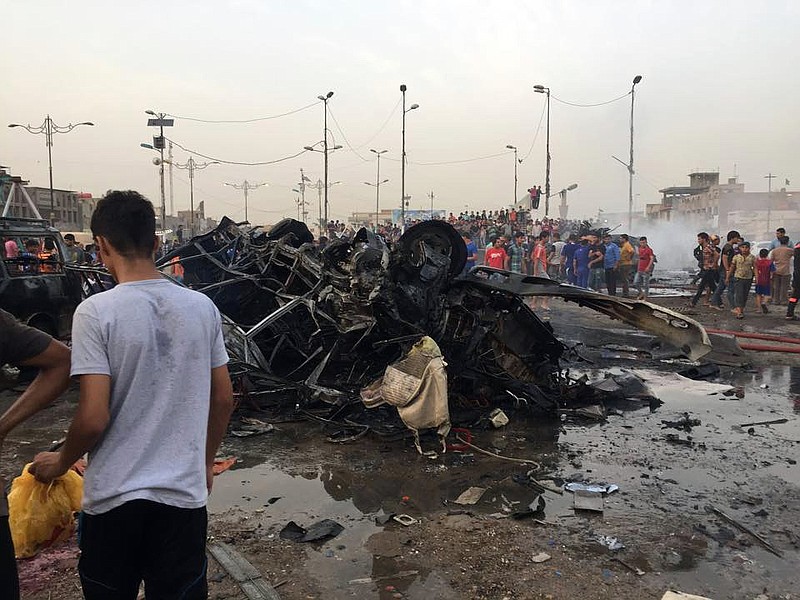 People and security forces gather at the scene of a car bomb explosion in the Shiite predominant district of Sadr city, Baghdad, Iraq, Wednesday, Aug. 5, 2015.
